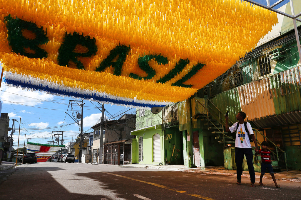 Pedestrians walk beneath street decorations ahead of the 2026 FIFA World Cup, in Manaus, Brazil, Sunday, May 17, 2026. (AP Photo/Edmar Barros)