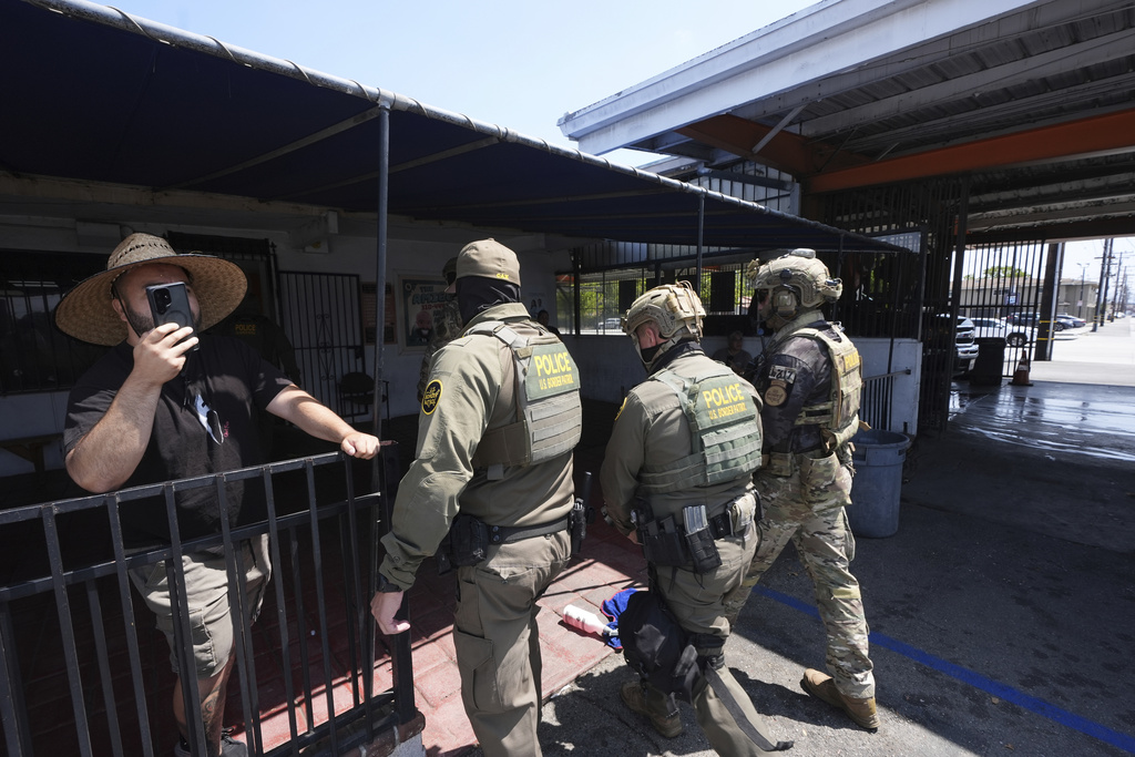 Immigration agents conduct an operation at a car wash on Friday, Aug. 15, 2025, in Montebello, Calif. (AP Photo/Gregory Bull)