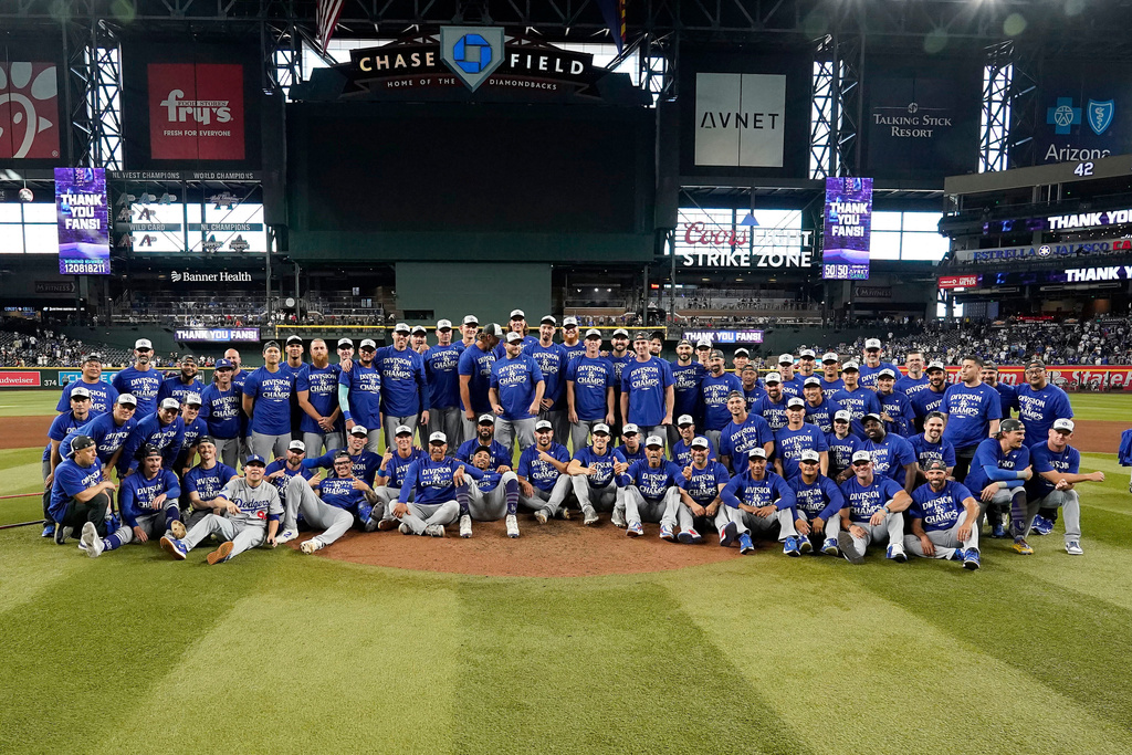 Los Angeles Dodgers players and coaches after the Dodgers clinched the National League West title against the Arizona Diamondbacks during a baseball game at Chase Field Thursday, Sept. 25, 2025, in Phoenix. (AP Photo/Darryl Webb)