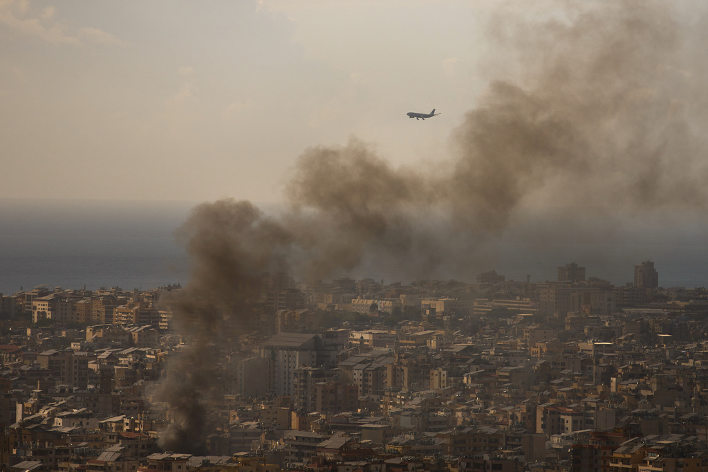 A commercial plane is preparing to land at Beirut Airport as smoke rises from Israeli airstrikes in Dahiyeh, a southern suburb of Beirut, Lebanon, Sunday, April 5, 2026. (AP Photo/Emilio Morenatti)
