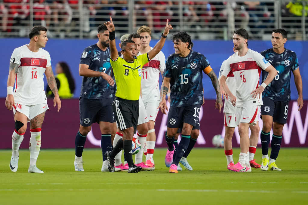 Referee Ivan Arcides Barton Cisneros, of El Salvador, signals to ask for a VAR review before issuing a red card to Paraguay's Miguel Almiron (10) during the World Cup Group D soccer match between Turkey and Paraguay in Santa Clara, Calif., near San Francisco, Friday, June 19, 2026. (AP Photo/Eugene Hoshiko)