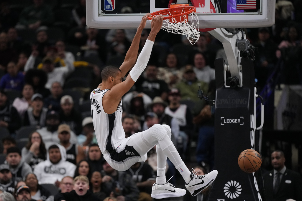 San Antonio Spurs forward Victor Wembanyama (1) scores against the Orlando Magic during the first half of an NBA basketball game in San Antonio, Sunday, Feb. 1, 2026. (AP Photo/Eric Gay)
