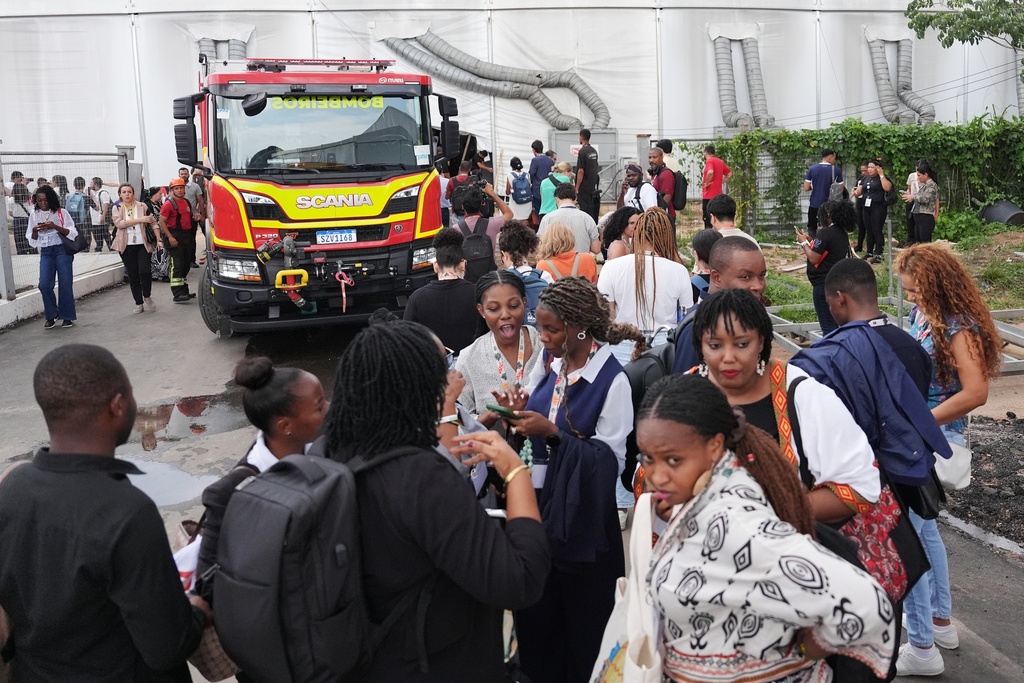Attendees evacuate after a fire was reported inside the venue for the COP30 U.N. Climate Summit, Thursday, Nov. 20, 2025, in Belem, Brazil. (AP Photo/Joshua A. Bickel)