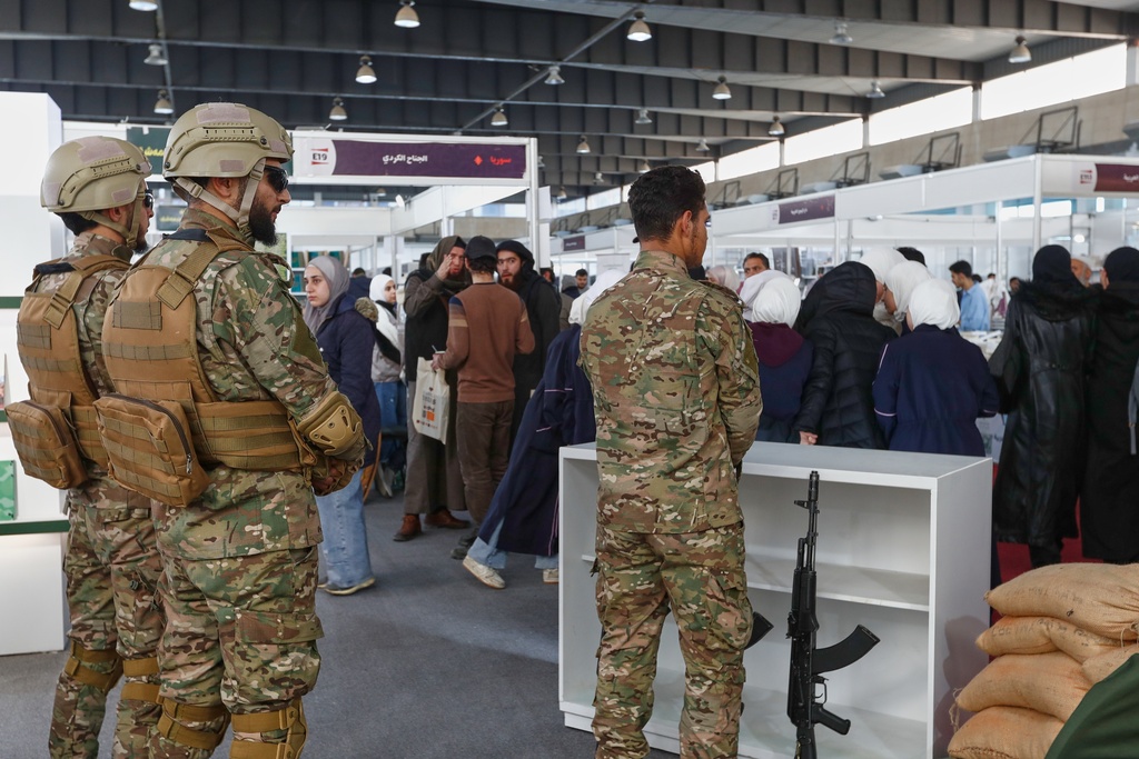 Syrian soldiers staff a stall operated by the Syrian Defense Ministry during the 57th Damascus International Book Fair in Damascus, Syria, Monday, Feb. 16, 2026, the first edition since the collapse of the Assad regime. (AP Photo/Omar Sanadiki)