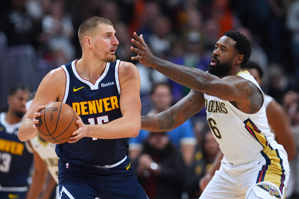 Denver Nuggets center Nikola Jokić, left, looks to pass the ball as New Orleans Pelicans center DeAndre Jordan, right, defends in the first half of an NBA basketball game Saturday, Oct. 24, 2026, in Denver. (AP Photo/David Zalubowski)