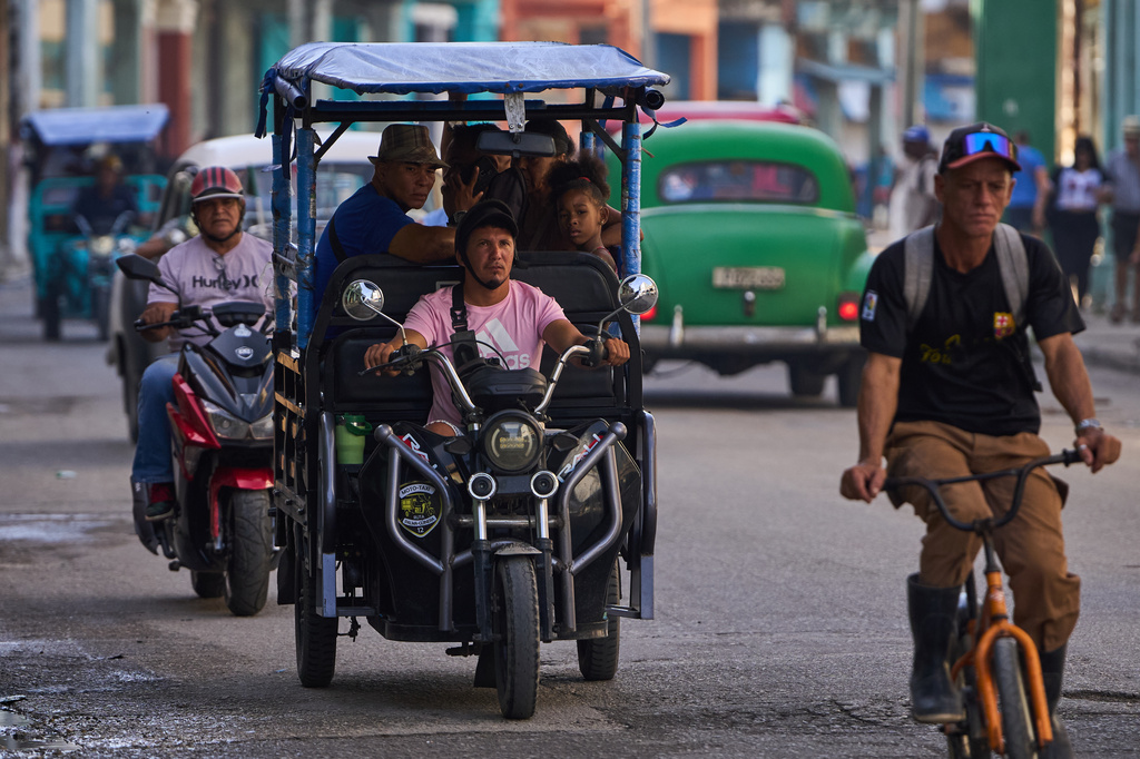 People ride in an electric tricycle in Havana, Cuba, Friday, July 10, 2026. (AP Photo/Ramon Espinosa)