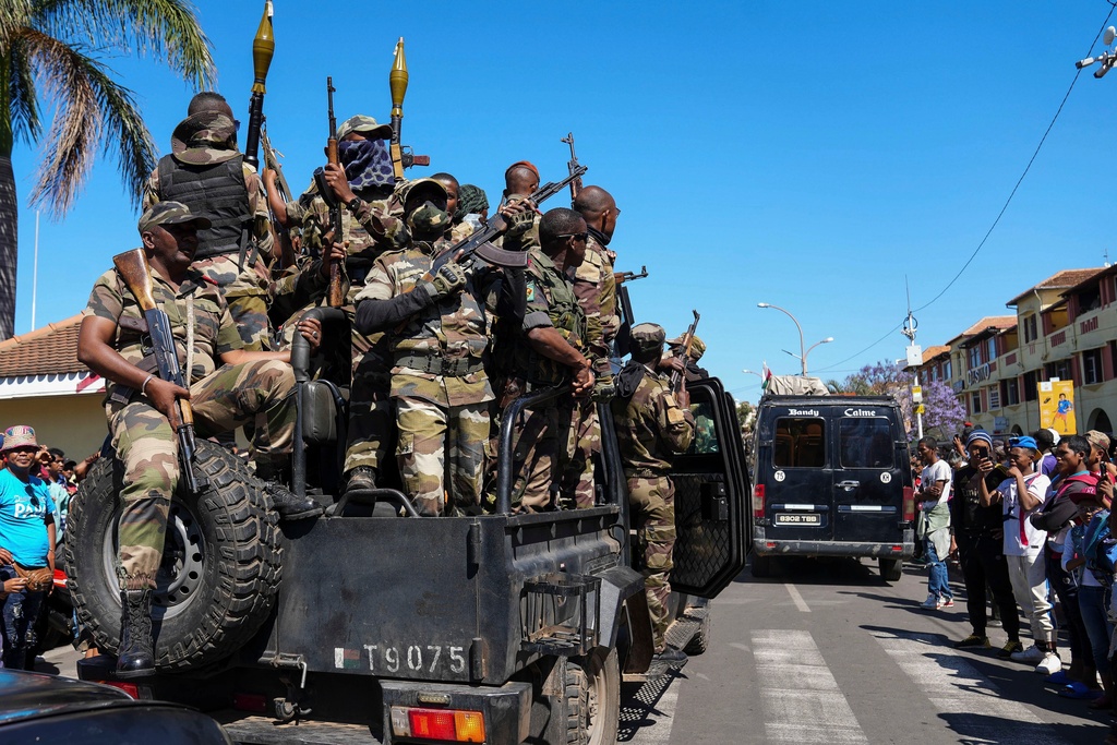 Soldiers are greeted by people gathering for a ceremony in tribute to demonstrators killed during recent anti-government protest in Antananarivo, Madagascar, Sunday, Oct. 12, 2025. (AP Photo/Mamyrael)