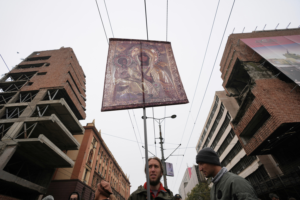 A man holds an Christian Orthodox icon during a protest in front of military complex that was partially destroyed in a NATO bombing campaign in 1999, after Serbian lawmakers on Friday passed a special law clearing the way for a controversial real estate project that would be financed by an investment company linked to President Trump's son-in-law Jared Kushner, in Belgrade, Serbia, Tuesday, Nov. 11, 2025. (AP Photo/Darko Vojinovic)