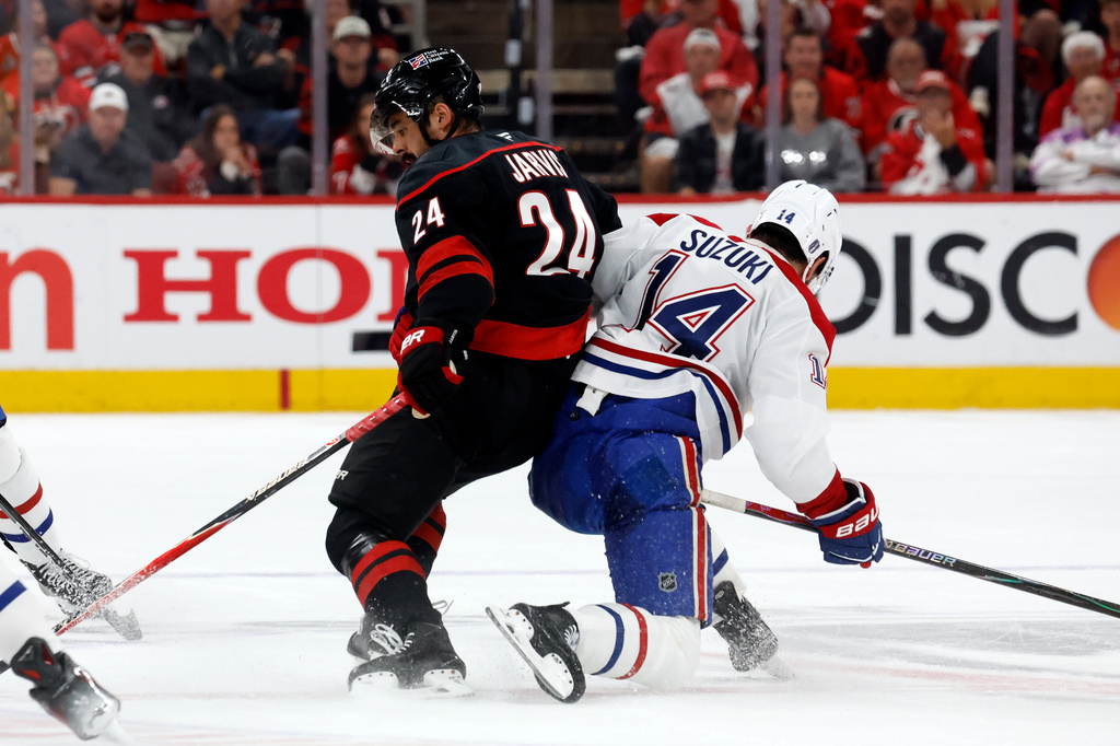 Carolina Hurricanes' Seth Jarvis (24) collides with Montréal Canadiens' Nick Suzuki (14) during the first period in Game 1 of the Eastern Conference finals NHL hockey Stanley Cup playoffs series in Raleigh, N.C., Thursday, May 21, 2026. (AP Photo/Karl DeBlaker)