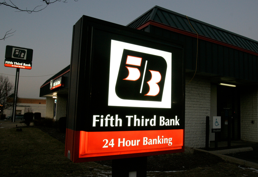FILE - In this Jan. 21, 2009 file photo, signs outside a Fifth Third Bank are lit up at dusk in Cincinnati.(AP Photo/Al Behrman, file)