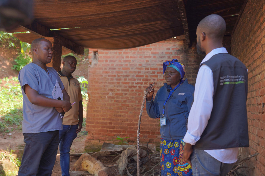 Gédéon Banga Ngbape, left, an Ebola surveillance officer, does contact tracing in Nizi, Ituri province, eastern Congo, Friday, Aug. 14, 2026. (AP Photo/Dieudonne Dirole)