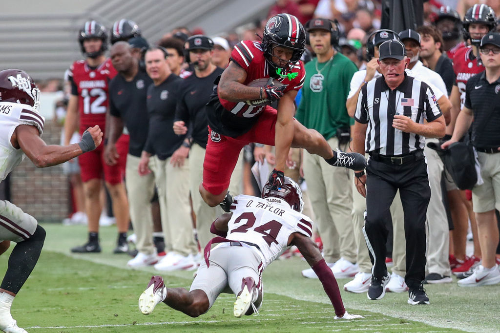 South Carolina running back Christian Clark (10) hurdles Mississippi State cornerback Quentin Taylor (24) for extra yards during the first half of an NCAA college football game Saturday, Sept. 19, 2026, in Columbia, S.C. (AP Photo/Artie Walker Jr.)