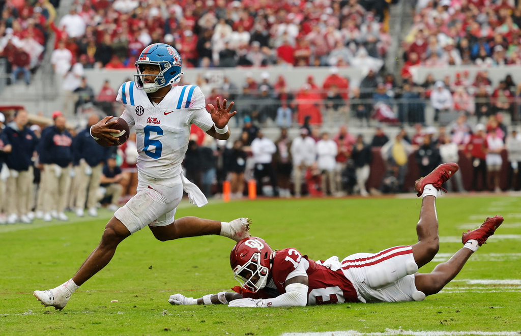 Mississippi quarterback Trinidad Chambliss (6) escapes a tackle by Oklahoma for a first down during the first half of an NCAA college football game in Norman, Okla., Saturday, Oct. 25, 2025. (AP Photo/Alonzo Adams)