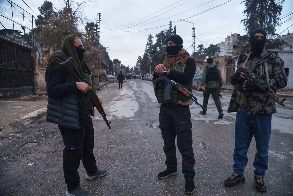 Kurdish-led Syrian Democratic Forces (SDF) combatants secure the area after the arrival of Syria's Interior Ministry security forces, deployed under an agreement aimed at stabilizing a ceasefire, in Qamishli, eastern Syria, Tuesday, Feb. 3, 2026. (AP Photo/Baderkhan Ahmad)