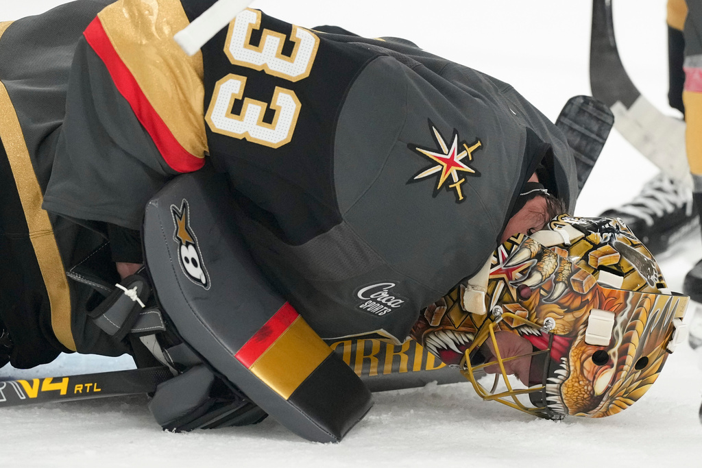 Vegas Golden Knights goaltender Adin Hill lies on the ice after a play against the Carolina Hurricanes during the first period of an NHL hockey game Monday, Oct. 20, 2025, in Las Vegas. (AP Photo/Candice Ward)