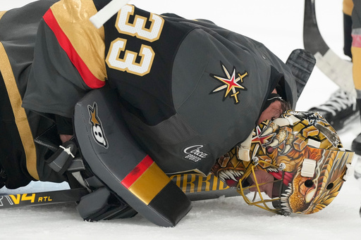 Vegas Golden Knights goaltender Adin Hill lies on the ice after a play against the Carolina Hurricanes during the first period of an NHL hockey game Monday, Oct. 20, 2025, in Las Vegas. (AP Photo/Candice Ward) Vegas Golden Knights goaltender Adin Hill lies on the ice after a play against the Carolina Hurricanes during the first period of an NHL hockey game Monday, Oct. 20, 2025, in Las Vegas. (AP Photo/Candice Ward)