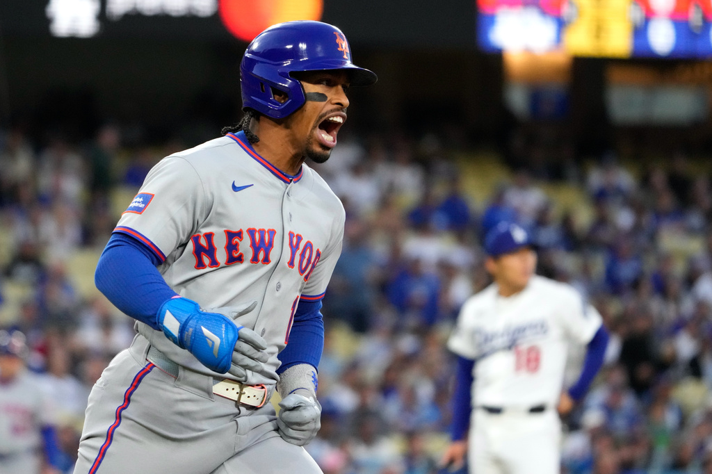 New York Mets' Francisco Lindor, left, celebrates as he heads to first for a solo home run as Los Angeles Dodgers starting pitcher Yoshinobu Yamamoto watches during the first inning of a baseball game Tuesday, April 14, 2026, in Los Angeles. (AP Photo/Mark J. Terrill)
