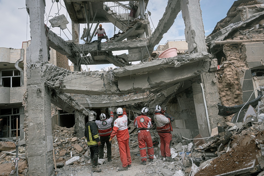 First responders inspect the remains of a residential building hit in an overnight strike during the U.S.-Israeli military campaign in Tabriz, East Azerbaijan Province, northwestern Iran, Tuesday, March 24, 2026. (AP Photo/Matin Hashemi)