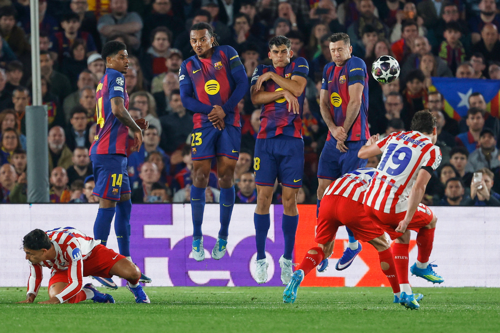 Atletico Madrid's Julian Alvarez, right, takes a free kick during the Champions League quarterfinal first leg soccer match between Barcelona and Atletico Madrid in Barcelona, Spain, Wednesday, April 8, 2026. (AP Photo/Joan Monfort)