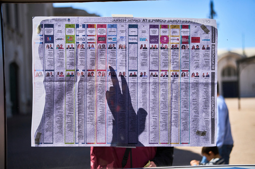A woman points on the list of candidates placed outside a polling station during legislative midterm elections in Buenos Aires, Argentina, Sunday, Oct. 26, 2025. (AP Photo/Rodrigo Abd) A woman points on the list of candidates placed outside a polling station during legislative midterm elections in Buenos Aires, Argentina, Sunday, Oct. 26, 2025. (AP Photo/Rodrigo Abd)
