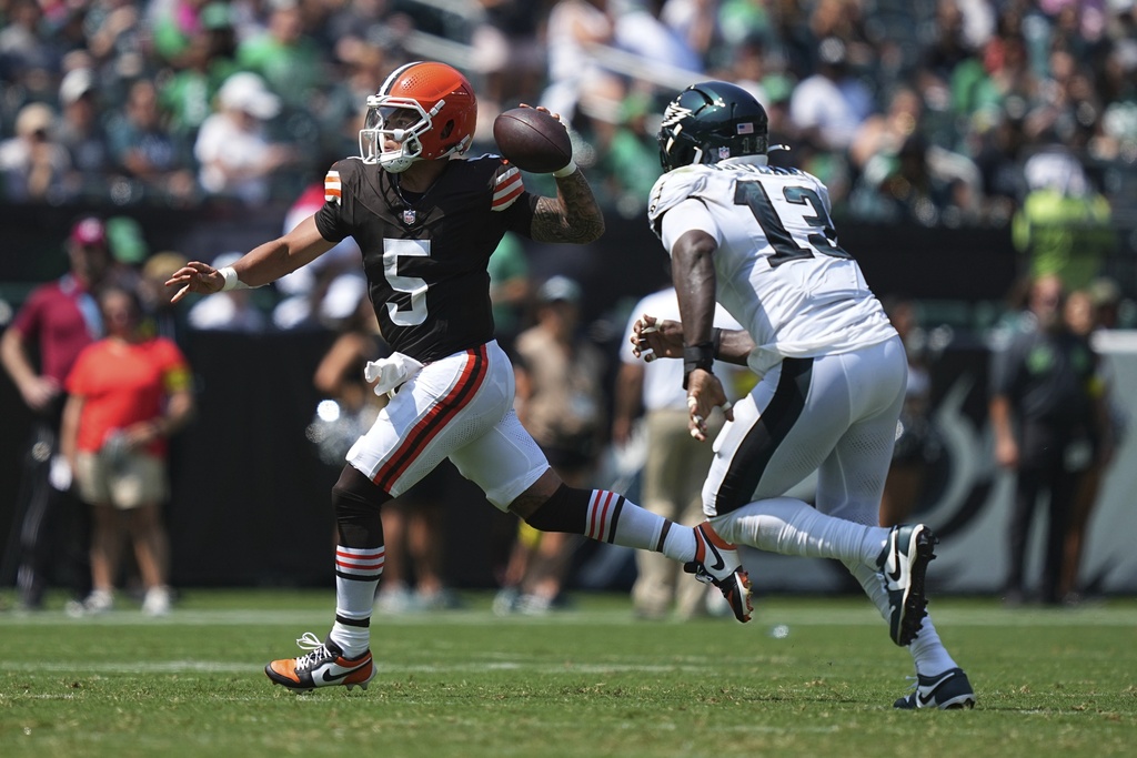 Cleveland Browns quarterback Dillon Gabriel (5) looks to pass under pressure from Philadelphia Eagles linebacker Azeez Ojulari (13) during the first half of an NFL preseason football game Saturday, Aug. 16, 2025, in Philadelphia. (AP Photo/Matt Rourke)
