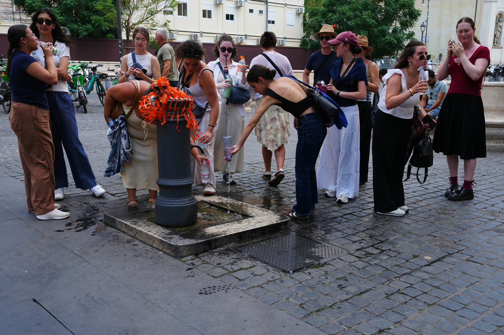 People cool off at a fountain in Rome, Tuesday, June 23, 2026. (AP Photo/Alessandra Tarantino)