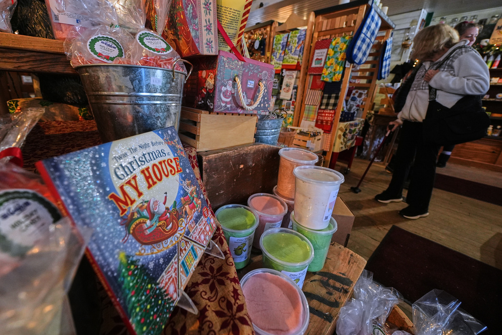 Post-holiday shoppers pass a seasonal candy and Christmas display at Calef's Country Store, Friday, Dec. 26, 2025, in Barrington, N.H. (AP Photo/Charles Krupa)