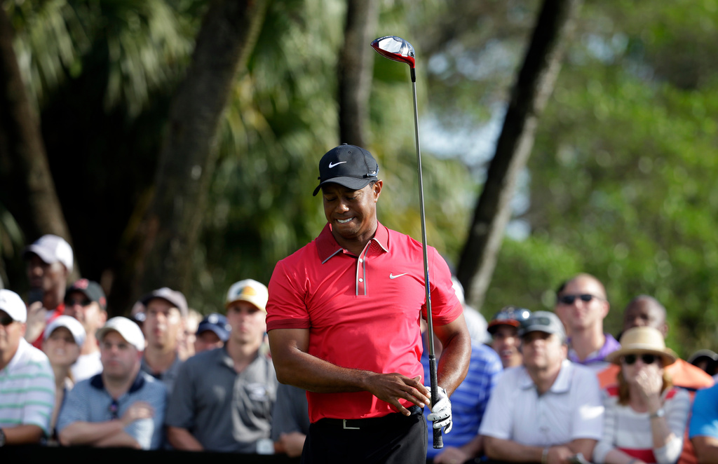 FILE - Tiger Woods grimaces after teeing off on the 12th hole during the final round of the Cadillac Championship golf tournament Sunday, March 9, 2014, in Doral, Fla. (AP Photo/Lynne Sladky, File)