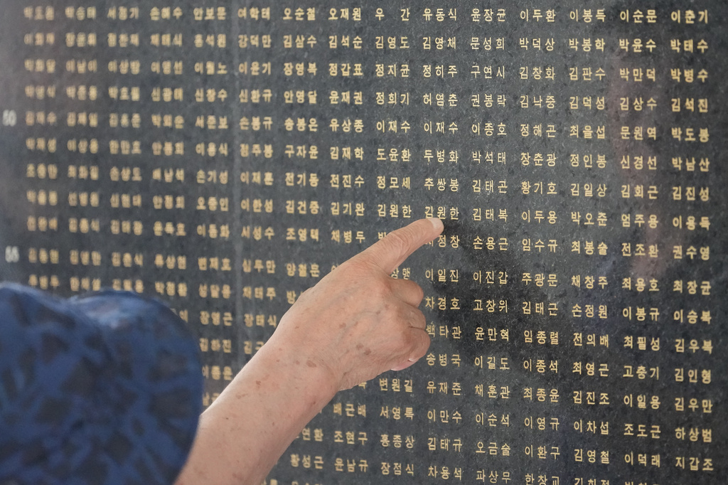 A South Korean man points a name of his brother who was killed in the Korean War in Seoul, South Korea, Sunday, July 5, 2026. (AP Photo/Lee Jin-man)