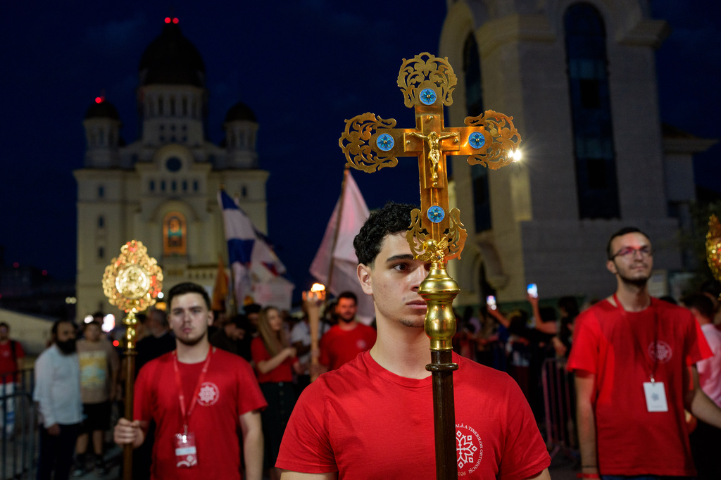 A young man carries a cross during the Procession of Lights, part of a four-day program of the International Meeting of Orthodox Youth (ITO), in Bucharest, Romania, Wednesday, Sept. 2, 2026. (AP Photo/Andreea Alexandru)
