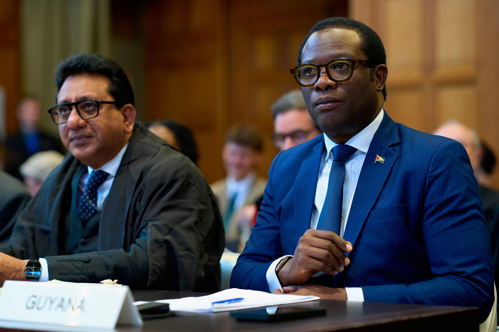 Guyana's Foreign Affairs minister Hugh Hilton Todd, right, and former Foreign Affairs minister Carl Greenidge, left, wait for the International Court of Justice to open a week of hearings in a border dispute dating back to the end of the 19th century between Guyana and Venezuela, in The Hague, Netherlands, Monday, May 4, 2026. (AP Photo/Peter Dejong)