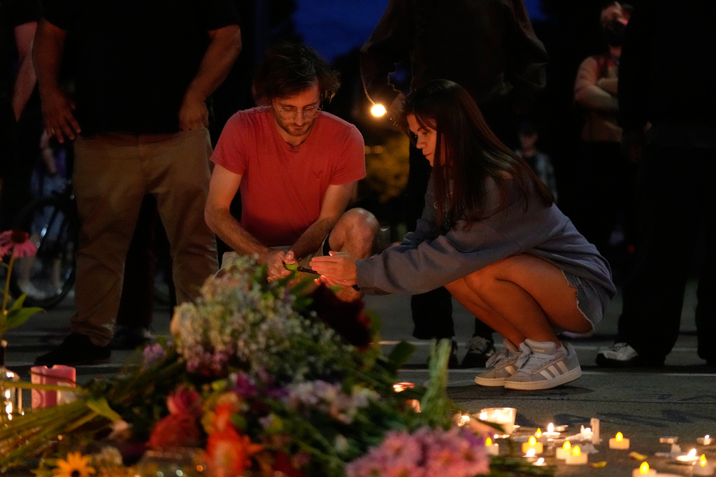 Attendees light candles at a candlelight vigil where a Madison police officer shot and killed a man Wednesday, July 22, 2026, in Madison, Wis. (AP Photo/Kayla Wolf)