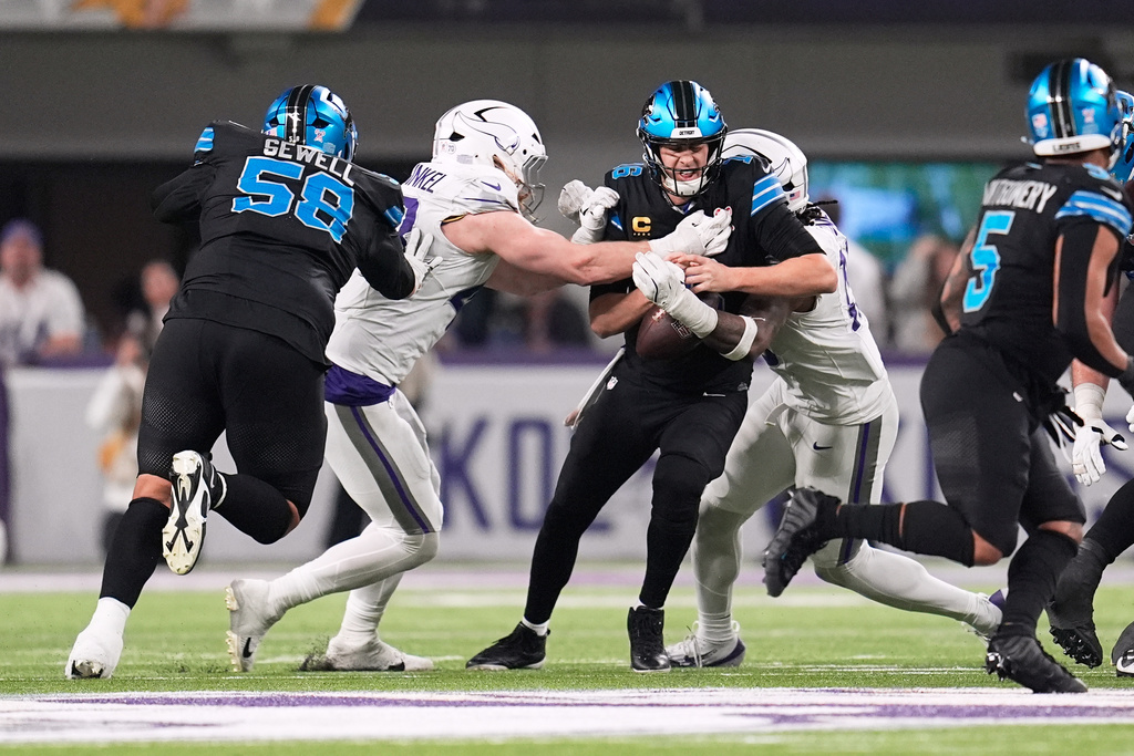 Detroit Lions quarterback Jared Goff, center, is sacked by Minnesota Vikings linebackers Andrew van Ginkel, second from left, and Dallas Turner, right, during the second half of an NFL football game, Thursday, Dec. 25, 2025, in Minneapolis. (AP Photo/Abbie Parr)
