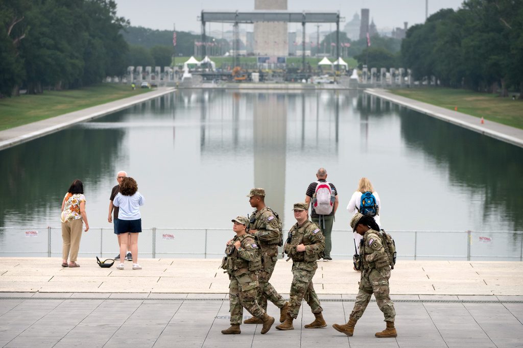 National Guard members walk past the Lincoln Memorial Reflecting Pool, Tuesday, July 7, 2026, in Washington. (AP Photo/Mark Schiefelbein)