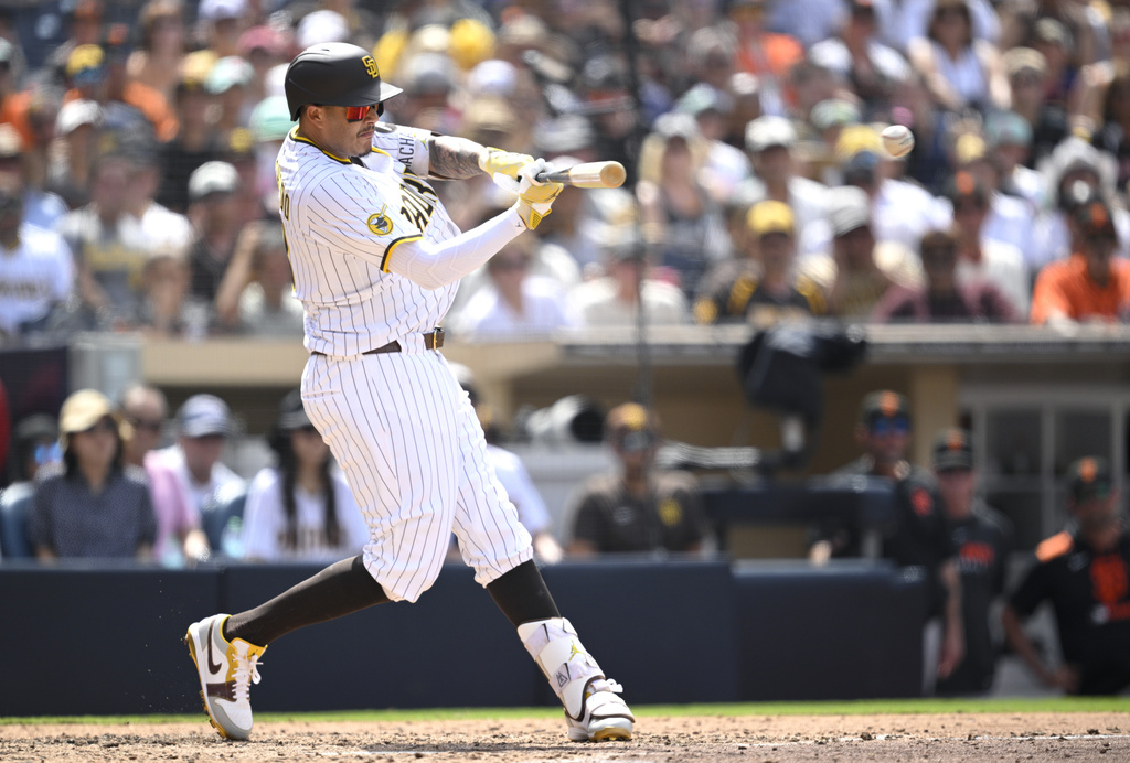 San Diego Padres' Manny Machado hits a two-RBI double during the fifth inning of a baseball game against the San Francisco Giants, Thursday, Aug. 21, 2025, in San Diego. (AP Photo/Orlando Ramirez)
