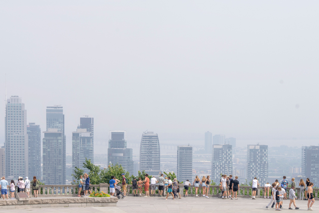 FILE - People visit the Mount Royal lookout in Montreal, July 14, 2025, as much of Central Canada and Manitoba were placed under special air quality statements or warnings, amid smoke from wildfires, and Environment Canada advised residents to limit time outdoors and watch for smoke exposure symptoms. (Christinne Muschi/The Canadian Press via AP, File)