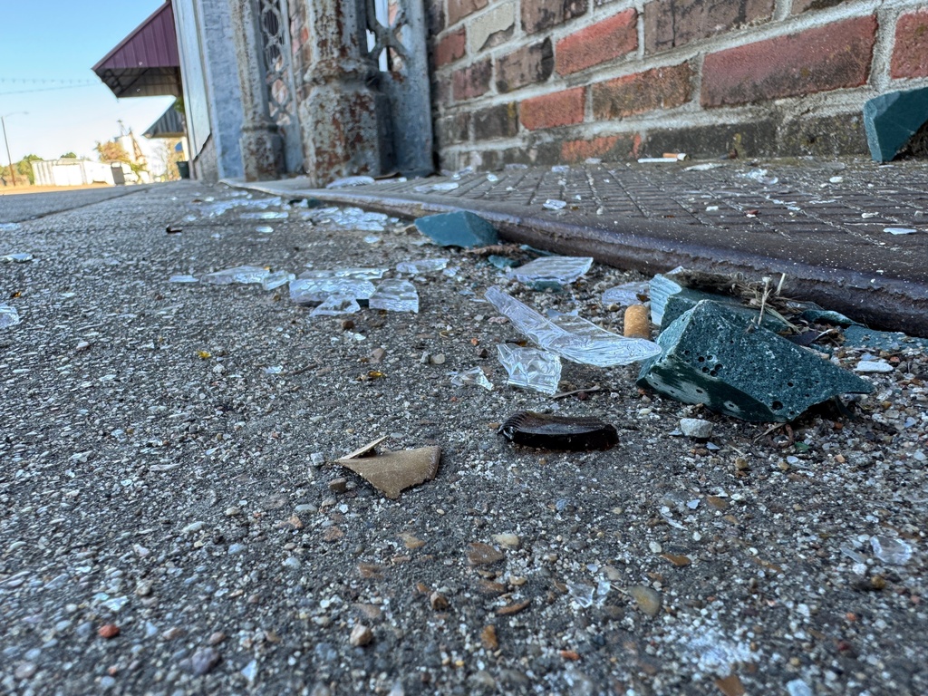Nearly a week after a mass shooting, shards of glass still littered parts of downtown Leland, Miss., on Thursday, Oct. 16, 2025. (AP Photo/Sophie Bates)