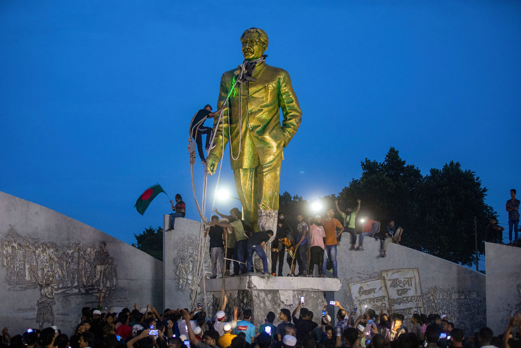 Protesters try to demolish a statue of Sheikh Mujibur Rahman, father of Bangladesh's leader Sheikh Hasina, after she resigned as Prime Minister, in Dhaka, Bangladesh, Monday, Aug. 5, 2024. (AP Photo/Rajib Dhar, File)