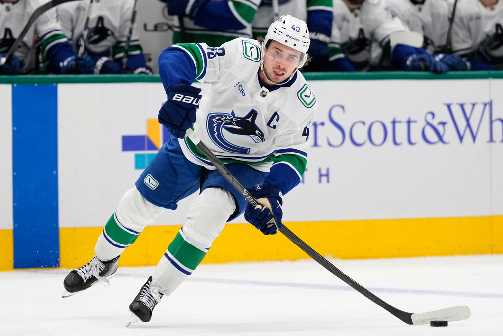 FILE - Vancouver Canucks defenseman Quinn Hughes makes a pass during an NHL hockey game against the Dallas Stars Thursday, Oct. 16, 2025, in Dallas. (AP Photo/Tony Gutierrez, File)