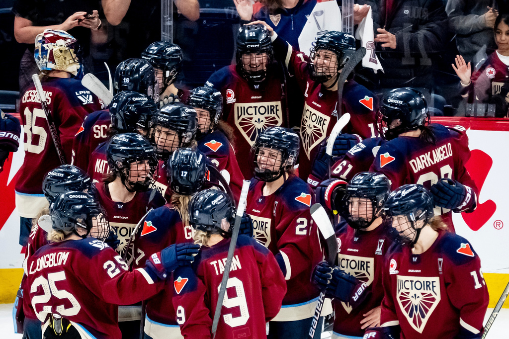 Montreal Victoire players celebrate after Maggie Flaherty (91), top center, scored scored the game winning goal against Ottawa Charge during overtime in Game 2 of the PWHL Walter Cup finals hockey series in Laval, Quebec, Saturday, May 16, 2026. (Christopher Katsarov/The Canadian Press via AP)