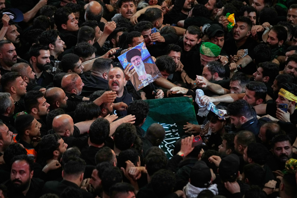 The coffin of the late Iranian Supreme Leader Ayatollah Ali Khamenei is carried through a tightly packed crowd as mourners jostle to reach and touch it outside the Imam Hussein Shrine in Karbala, Iraq, early Thursday, July 9, 2026. (AP Photo/Khalil Hamra)