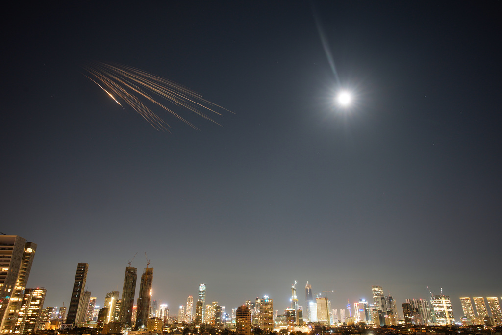 Missiles launched from Iran are seen in the sky over central Israel, Thursday, March 5, 2026. (AP Photo/Ohad Zwigenberg)