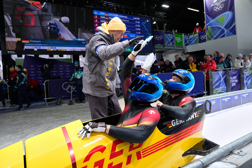Germany's Johannes Lochner, front, and Georg Fleischhauer, rear, arrive at the finish during a two man bobsled run at the 2026 Winter Olympics, in Cortina d'Ampezzo, Italy, Monday, Feb. 16, 2026. (AP Photo/Alessandra Tarantino)