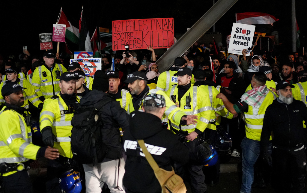 Police officers watch over pro-Palestinian protesters outside Villa Park during the Europa League soccer match between Aston Villa and Maccabi Tel Aviv in Birmingham, England, Thursday, Nov. 6, 2025. (Joe Giddens/PA via AP)