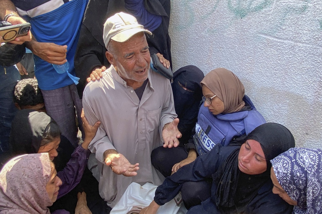 In this photo provided by a family member, Riyad Dagga, surrounded by relatives and friends, prays over the body of his daughter, freelance journalist Mariam Dagga, 33, during her funeral after she was killed in a double Israeli strike on Nasser Hospital in Khan Younis, southern Gaza Strip, Monday, Aug. 25, 2025. (Family Handout via AP)