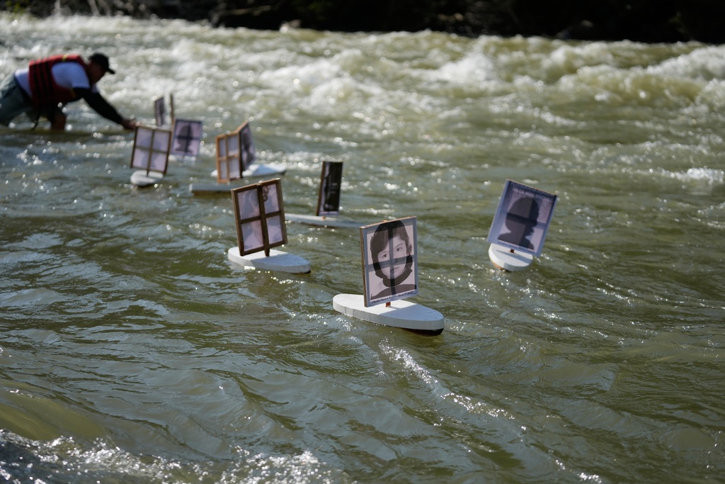 Families of children missing since the Nevado del Ruiz eruption release small boats with photos of the missing children, into the Guali River in Honda, Colombia, Wednesday, Nov. 12, 2025, on the eve of the 40th anniversary of the disaster that killed about 25,000 people. (AP Photo/Fernando Vergara)