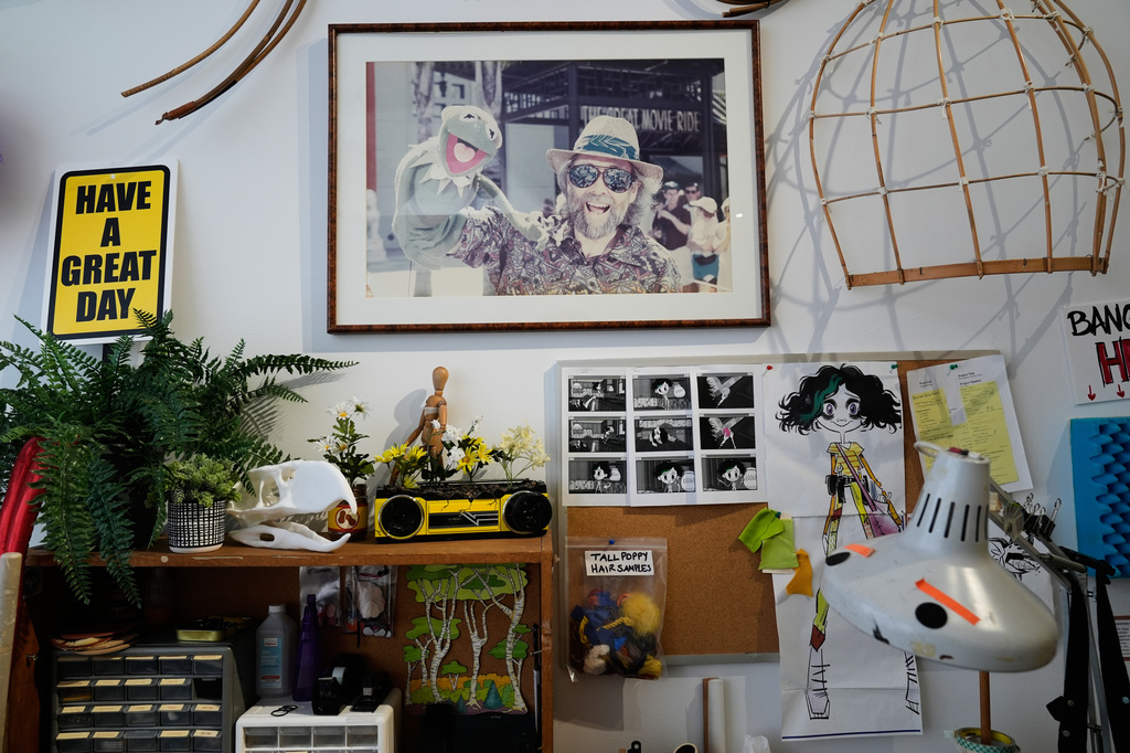 A re-creation of an artist's desk, with a photograph of Jim Henson and Kermit the Frog, is part of a tour at Jim Henson's Creature Shop in New York, Wednesday, May 13, 2026. (AP Photo/Seth Wenig)