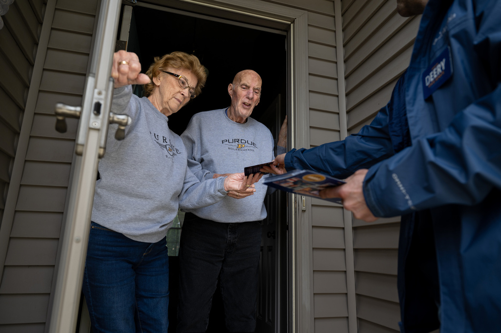 Retired couple Annette Williams, and her husband, Curtis Williams, speak with Indiana state Sen. Spencer Deery, R-West Lafayette, who represents District 23, after he stops at their home while canvassing a neighborhood, Saturday, April 11, 2026, in West Lafayette, Ind. (AP Photo/Doug McSchooler)