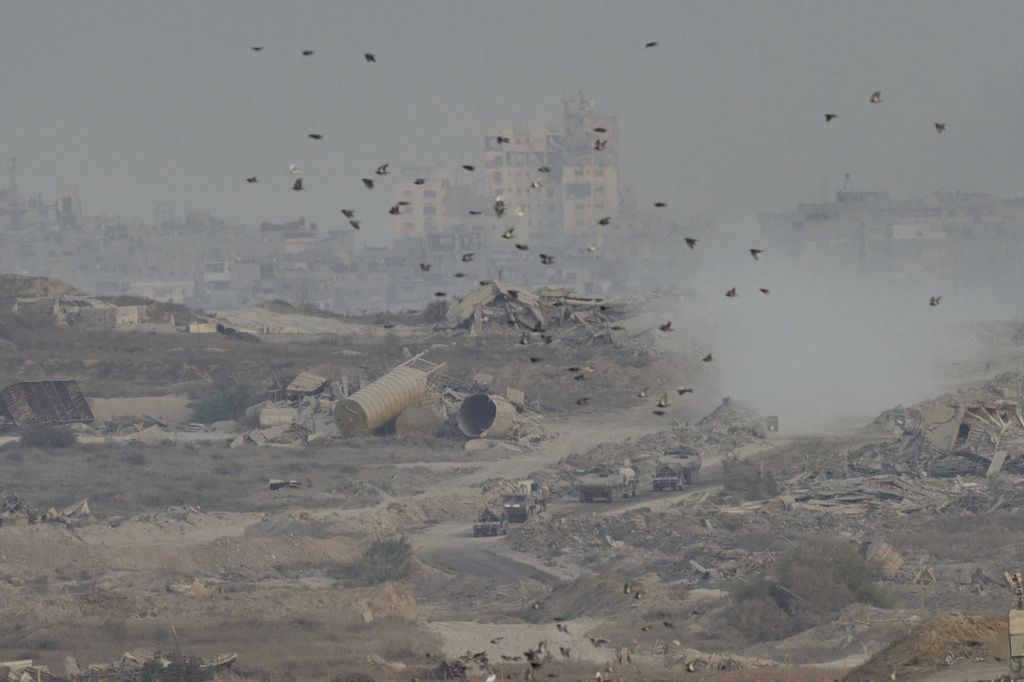 Israeli soldiers drive on their armored personnel carrier inside the northern Gaza Strip, as seen from southern Israel, Sunday, Sept. 21, 2025. (AP Photo/Ohad Zwigenberg)