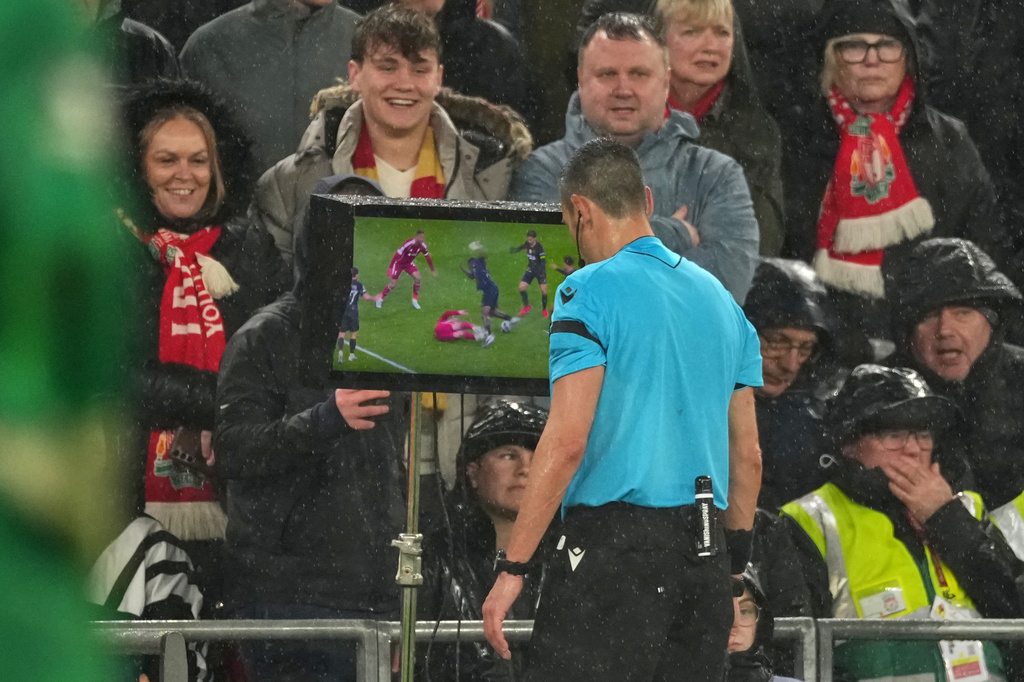 Referee Maurizio Mariani looks at a video replay before over ruling his original decision to award Liverpool a penalty after a VAR review during the Champions League quarterfinal second leg soccer match between Liverpool and Paris Saint-Germain in Liverpool, England, Tuesday, April 14, 2026. (AP Photo/Dave Shopland)